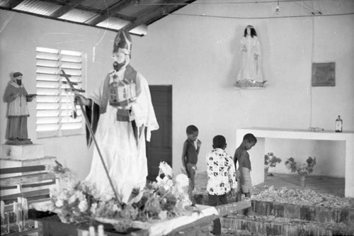 Children and a statue inside of the church, San Basilio de Palenque, 1975