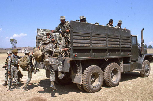 Soldiers climb onto the back of a truck at the military base, Santa Cruz del Quiché, 1982