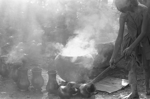 Girl with smoking clay jugs, La Chamba, Colombia, 1975