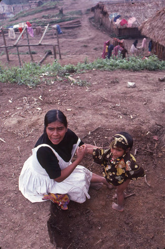 Guatemalan refugee dresses a child, Benito Juárez, 1983