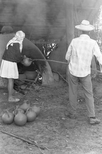 Man operating an oven, La Chamba, Colombia, 1975