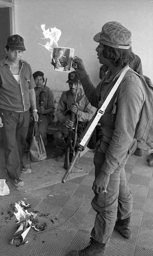 Sandinista burns a photo of Dictator Anastasio Somoza Garcia, Nicaragua, 1979