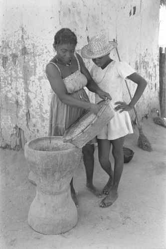 Woman pouring corn into mortar, San Basilio del Palenque, ca. 1978