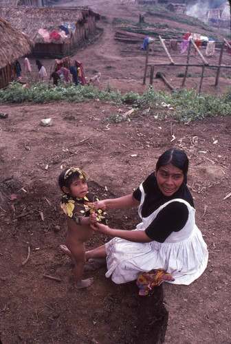 Guatemalan refugee dresses a child, Benito Juárez, 1983