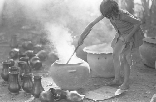 Girl with smoking clay jugs, La Chamba, Colombia, 1975