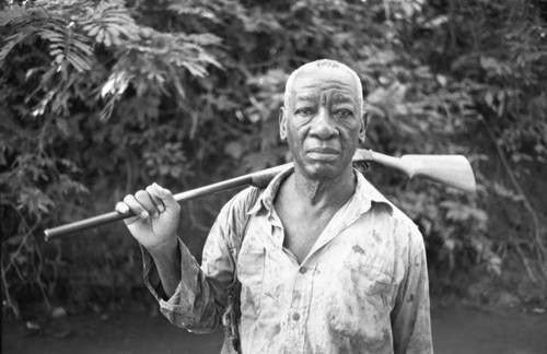 Fermín Herrera holds a rifle on his shoulder, San Basilio de Palenque, 1975