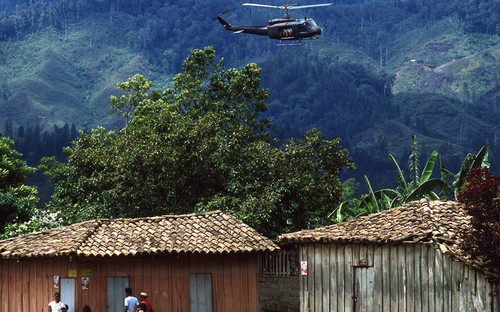 Contra helicopter flies over houses, Nicaragua, 1983