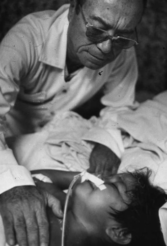 Man touches and injured child, Nicaragua, 1979