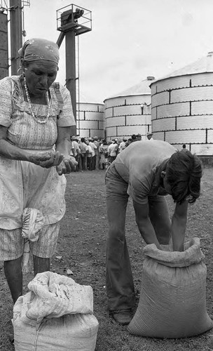 Woman and man sift grain, Nicaragua, 1980