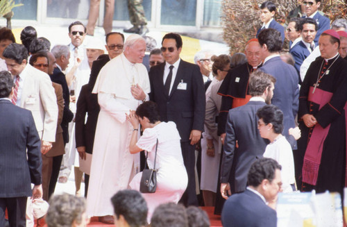 Pope John Paul II standing among clergy and officials, San Salvador, El Salvador, 1983