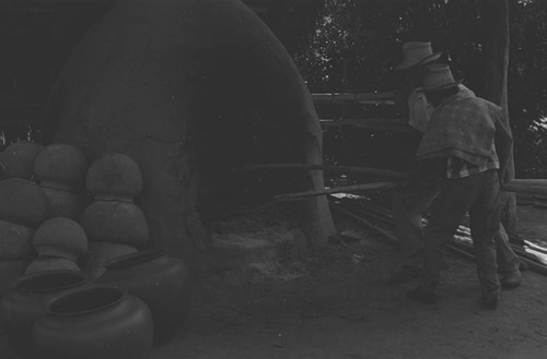 Men working the clay oven, La Chamba, Colombia, 1975