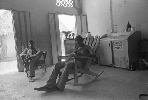 Young men sitting inside a store, San Basilio de Palenque, 1976