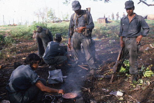 A young female Contra soldier cooks rice, Nicaragua, 1983