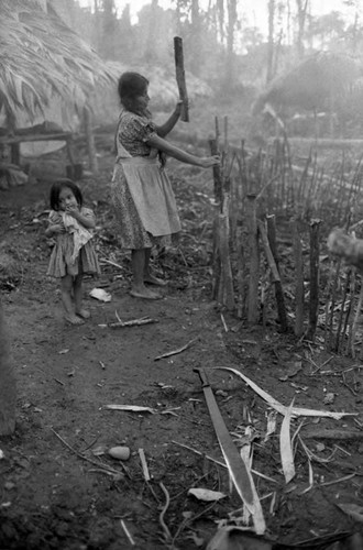 Refugee woman builds a fence of logs, Chiapas, 1983