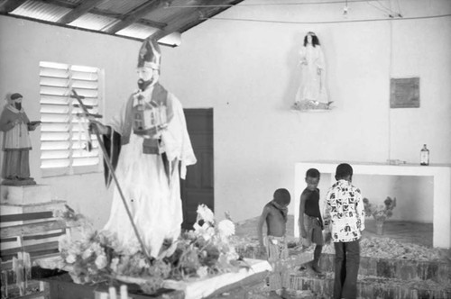 Children and a statue inside of the church, San Basilio de Palenque, 1975