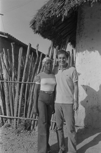 Richard Cross and woman standing in front of house, San Basilio de Palenque, ca. 1978