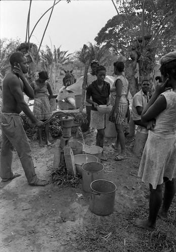Man pumping water from a hand pump, San Basilio de Palenque, 1977