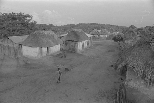 Woman walking with metal container on her head, San Basilio de Palenque, 1976