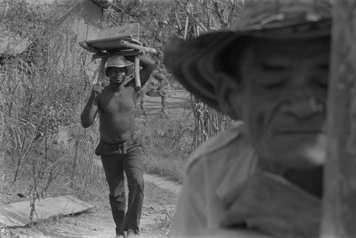 Man with load on his head walking, San Basilio del Palenque, ca. 1978