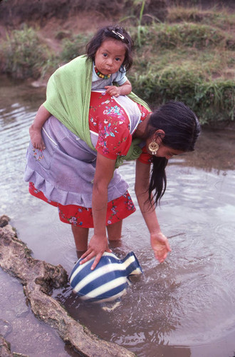 Guatemalan refugee collects water at a river, Cuauhtémoc, 1983