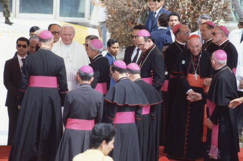 Pope John Paul II standing on a stage with clergy, San Salvador, El Salvador, 1983