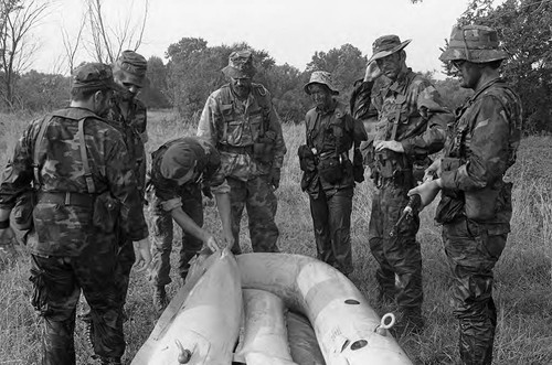 Survival school students stand near a raft, Liberal, 1982