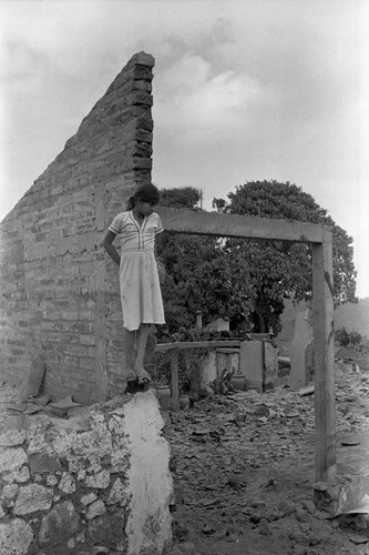 Girl standing on the edge of a destroyed wall, Berlín, 1983