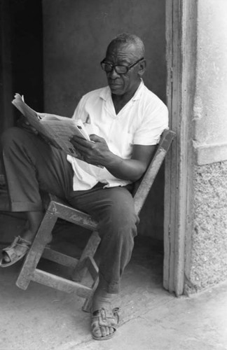 Fermín Herrera reading the newspaper San Basilio de Palenque, 1975