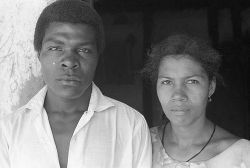 A man and a woman stand by a doorway, San Basilio de Palenque, 1975