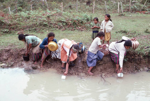 Guatemalan refugees collecting water at a River, Santiago el Vértice, 1983