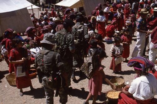 Three soldiers walking through a market, Chajul, 1982