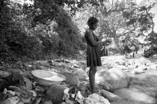 Woman washing clothes near river, La Guajira, Colombia, 1976