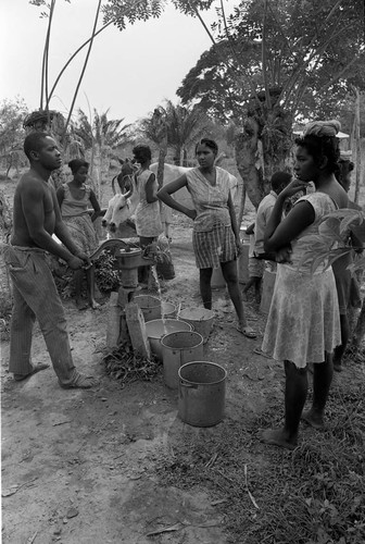 Man pumping water from a hand pump, San Basilio de Palenque, 1977