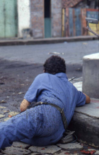 Sandinista taking cover near a curb, Nicaragua, 1979