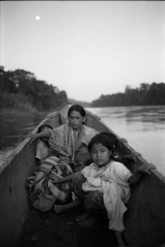 Refugee woman and three children in a canoe, Chiapas, 1983