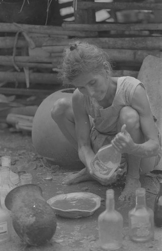 Woman working with bottles, La Chamba, Colombia, 1975