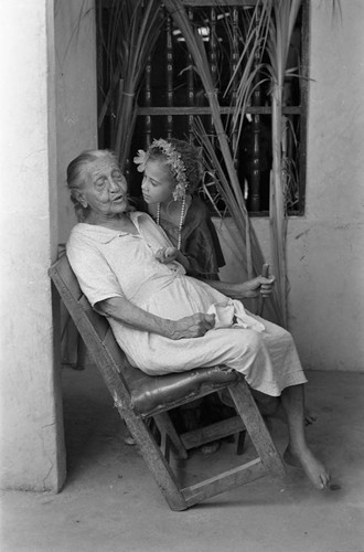 Girl talking with an elderly woman on a veranda, Barranquilla, Colombia, 1977
