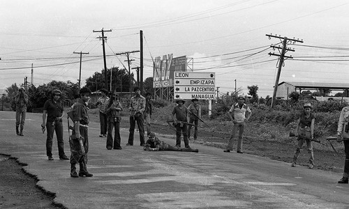 Sandinistas pose in front of a road sign, Nicaragua, 1979