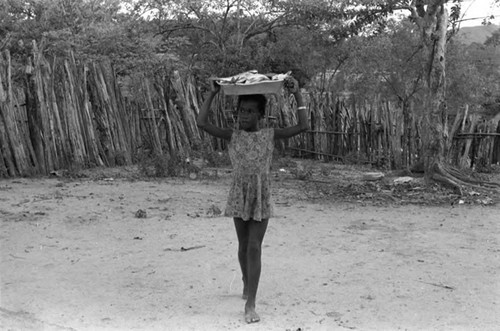 Girl walking with bowl of fish on her head, San Basilio de Palenque, 1975