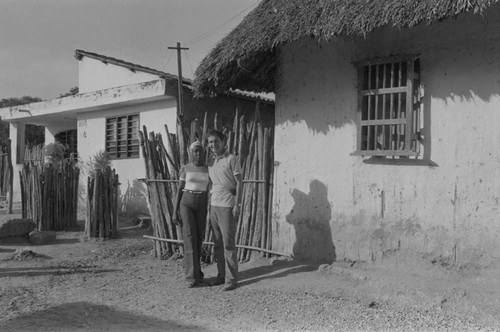 Richard Cross and woman standing in front of house, San Basilio de Palenque, ca. 1978