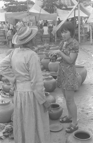 Woman buying clay goods at the market, La Chamba, Colombia, 1975