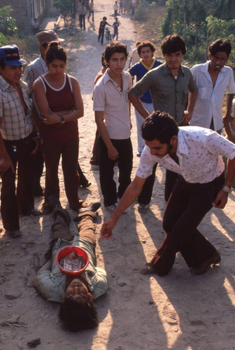 People gathering around dead body, Apopa, San Salvador, El Salvador, 1981