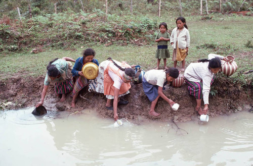 Guatemalan refugees collecting water at a River, Santiago el Vértice, 1983