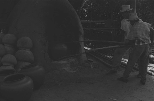 Men working the clay oven, La Chamba, Colombia, 1975