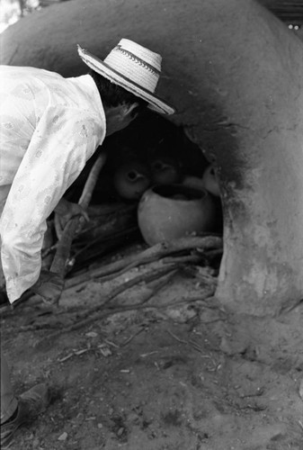 Man operating an oven, La Chamba, Colombia, 1975