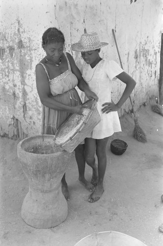 Woman pouring corn into mortar, San Basilio del Palenque, ca. 1978