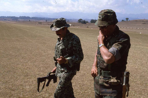 Benedicto Lucas García walking with an armed officer, Santa Cruz del Quiché, 1982