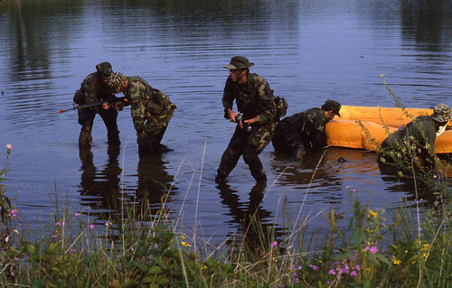 Survival school students stand near a raft, Liberal, 1982