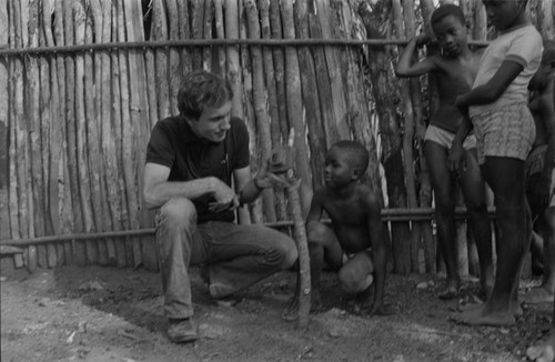 Richard Cross and a boy examining a toy camera, San Basilio de Palenque, 1977