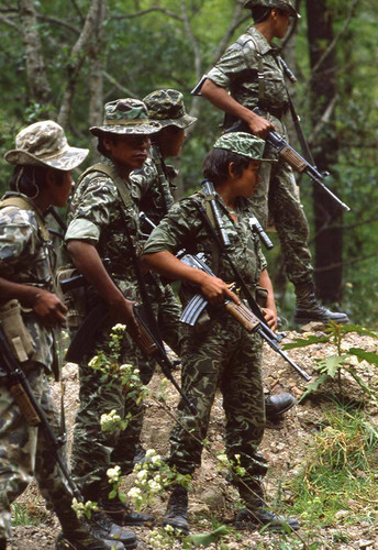 Five armed soldiers patrol wooded area, Chichicastenango, 1982